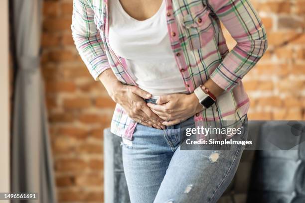 a woman is in pain due to a gallbladder attack or gallstones - inflamação imagens e fotografias de stock