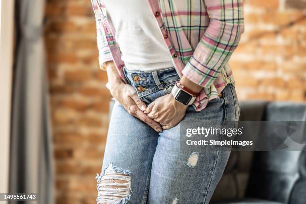 woman with hands holding her crotch due to urinary tract infection. - virilha humana imagens e fotografias de stock