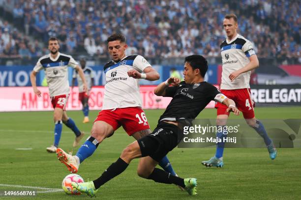 Francisco Montero Rubio of Hamburger SV battles for possession with Wataru Endo of VfB Stuttgart during the Bundesliga playoffs second leg match...