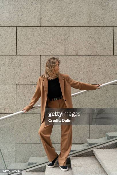 portrait of a businesswoman in a pant suit standing on steps outside a building, belarus - pantalón mujer fotografías e imágenes de stock