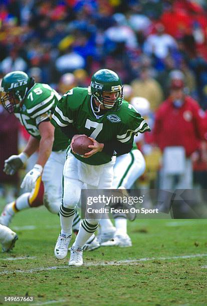 Boomer Esiason of the New York Jets turns to hand the ball off to a running back against the Washington Redskins during an NFL football game at...