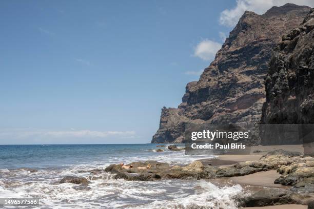 man inside a natural pool on the beach, playa guigui . gran canaria , spain - salt flat stock pictures, royalty-free photos & images