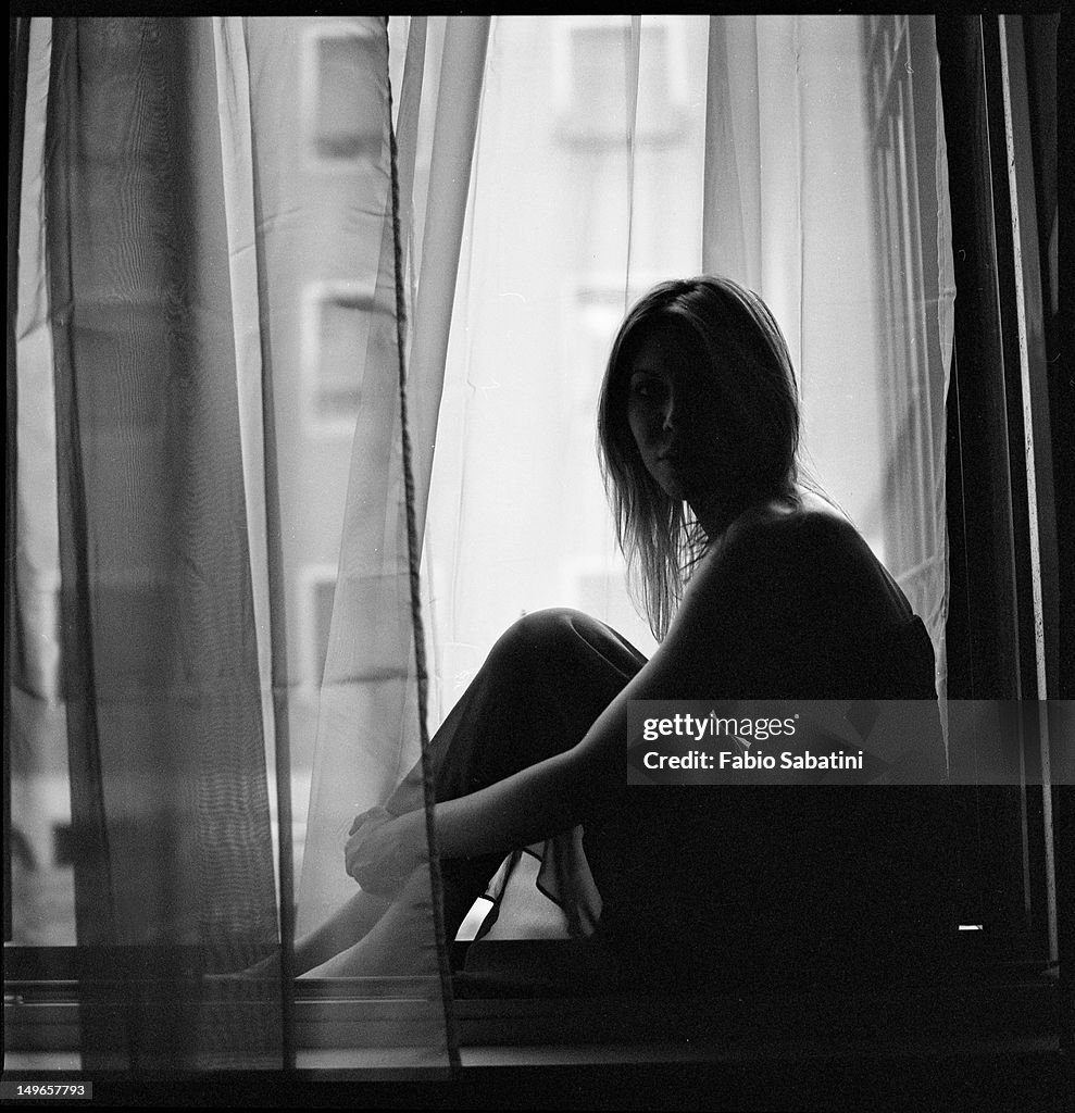 Girl sitting on window ledge