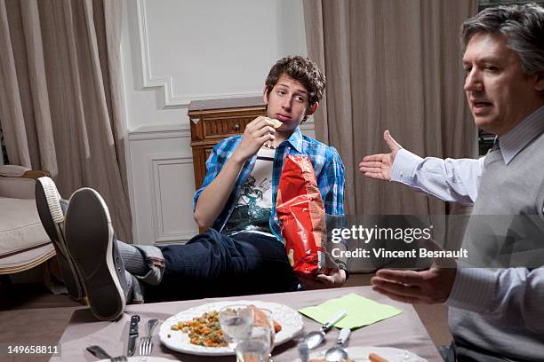father and son at the dinner table - mépris photos et images de collection