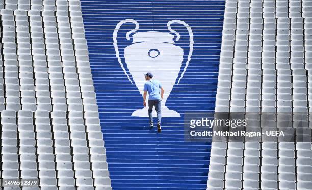 Member of the UEFA workforce walks over branding depicting the Champions League trophy ahead of the UEFA Champions League 2022/23 final on June 07,...