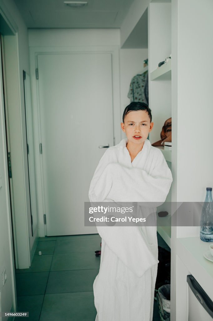 Portrait of a boy wearing a big bathrobe probably it´s belong to his father