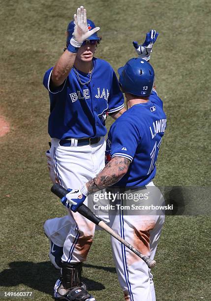 Colby Rasmus of the Toronto Blue Jays is congratulated by Brett Lawrie after hitting a two-run home run in the seventh inning during MLB game action...