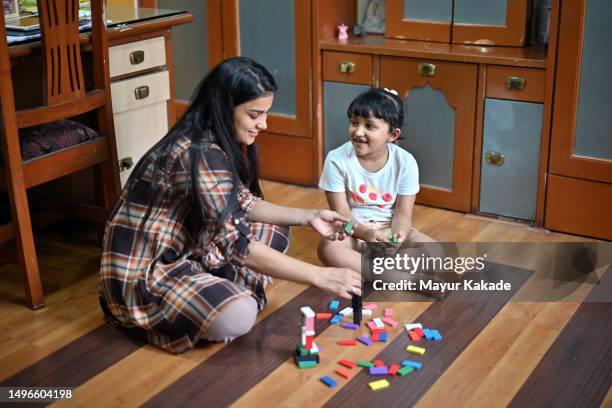 a loving mother playing wooden blocks with her daughter - messing about stock pictures, royalty-free photos & images