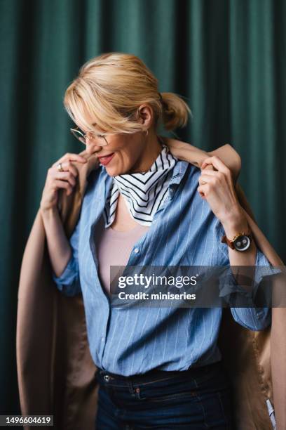 happy business woman putting on coat in the restaurant - leaving restaurant stock pictures, royalty-free photos & images