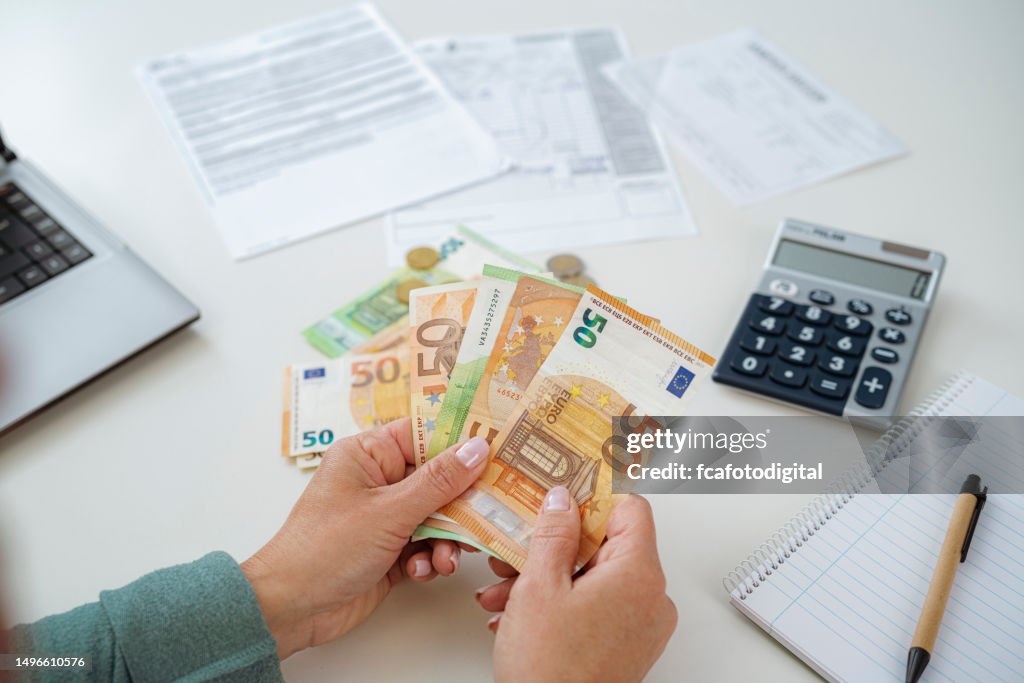 Close up of woman's hands counting Euro banknotes planning home budget