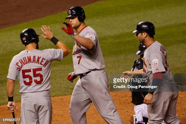 Matt Holliday of the St. Louis Cardinals is welcomed home by Skip Schumaker and Daniel Descalso of the Cardinals after his three run home run off of...