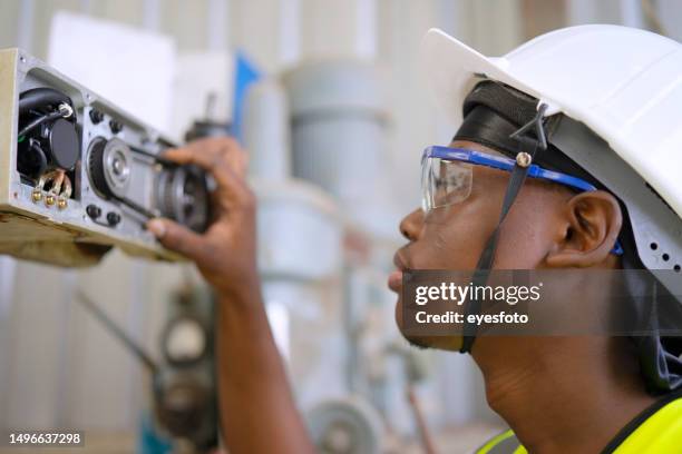 blue collar worker is fixing welding robot arm. - riemlus stockfoto's en -beelden