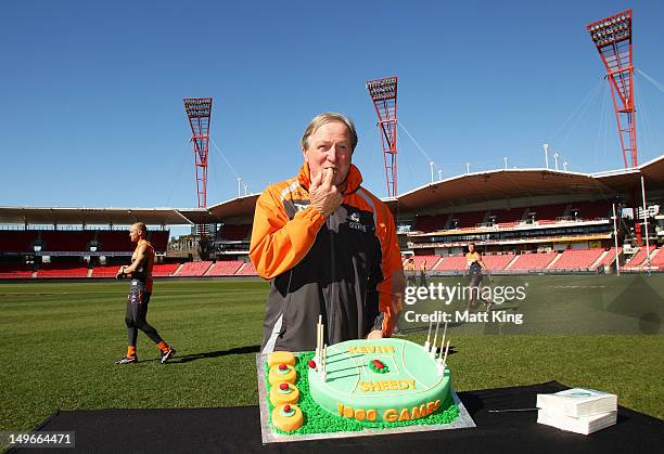 Kevin Sheedy samples a cake after it was presented to him by Giants players and staff to commemorate his 100th game before a GWS Giants AFL training...