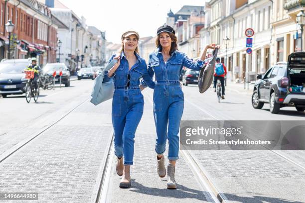 German actress Gerit Kling, wearing beige booties by EPO, a blue jeanns jumpsuit by Marco Macru, a light khaki colored bag by Bottega Veneta, a black...