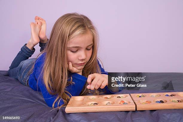 young girl playing the game, mancala. - mancala stockfoto's en -beelden