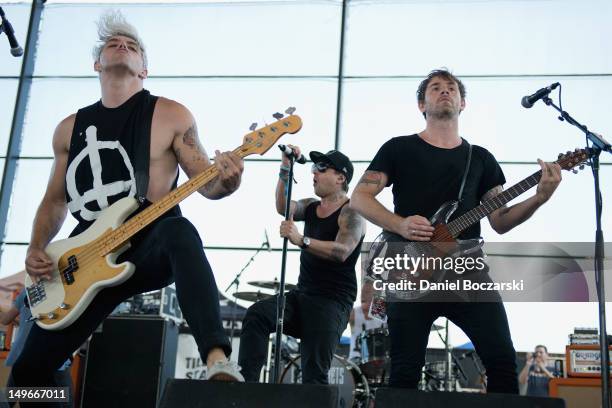 Stuart Richardson, Ian Watkins and Mike Lewis of Lostprophets perform on stage during Warped Tour at Marcus Amphitheatre on August 1, 2012 in...