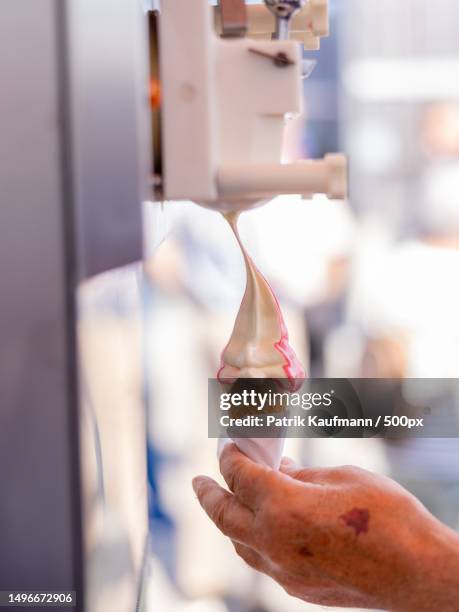 cropped hand of person holding ice cream,lindau,switzerland - softeis stock-fotos und bilder