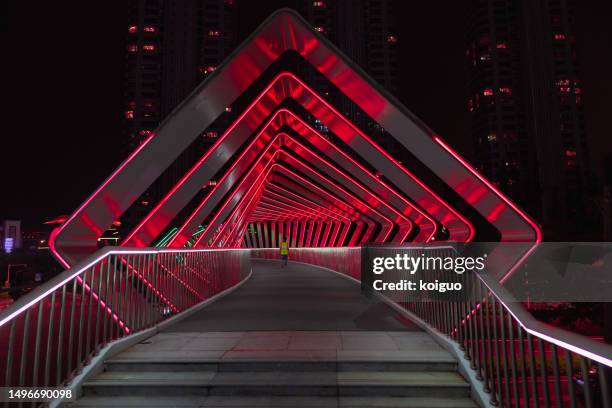 pedestrians crossing a pedestrian bridge with light effects - passerelle pont photos et images de collection