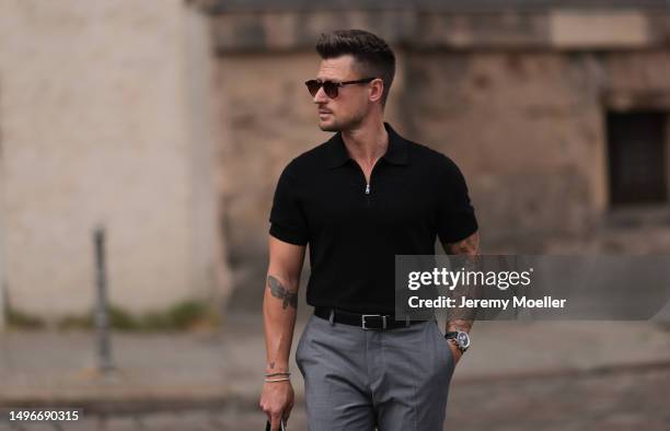 Andre Hellmundt wearing Saint Laurent black leather business clutch, Gant black leather loafer, Hechter Paris grey suit pants, Massimo Dutti black...