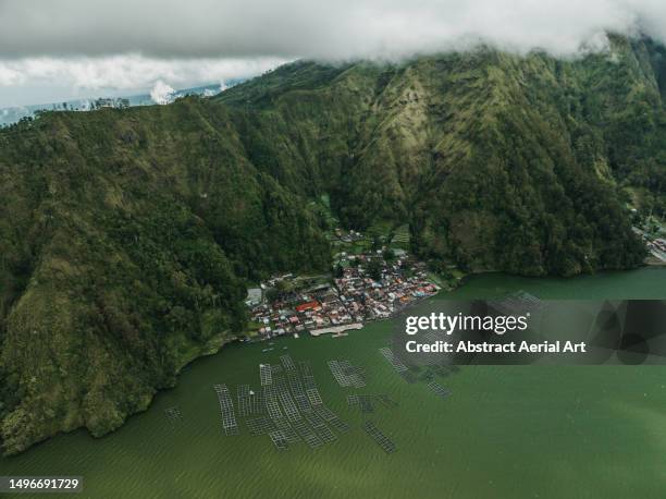 aerial image showing a fishing community in the cliffs of a crater lake, mount batur, bali, indonesia - mountain village stockfoto's en -beelden