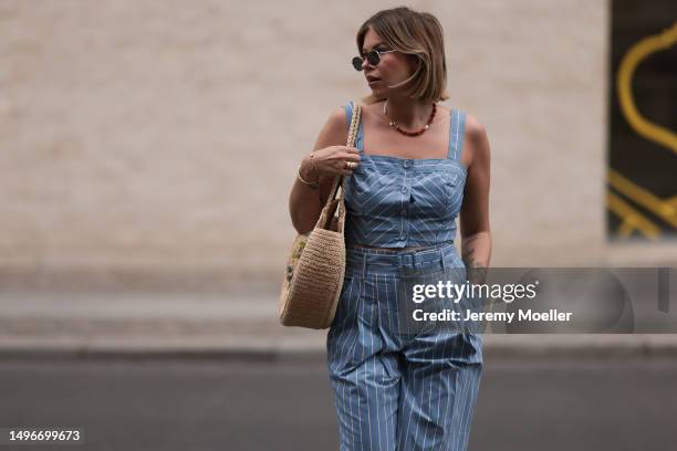 Aline Kaplan wearing Veronica Beard striped blue, green, white cropped top and Veronica Beard matching wide leg pants, Sezane raffia round bag, &...