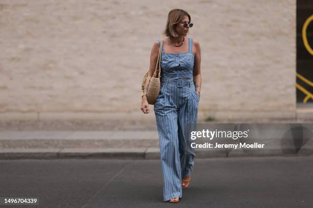 Aline Kaplan wearing Veronica Beard striped blue, green, white cropped top and Veronica Beard matching wide leg pants, Sezane raffia round bag, &...