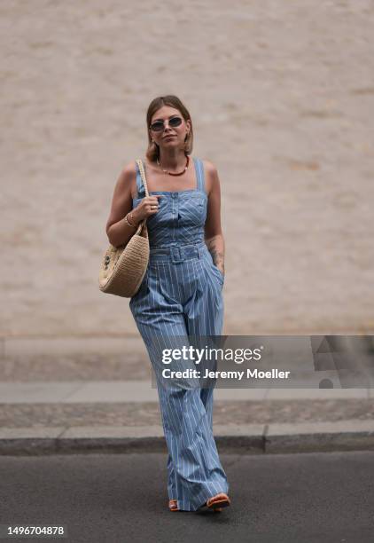 Aline Kaplan wearing Veronica Beard striped blue, green, white cropped top and Veronica Beard matching wide leg pants, Sezane raffia round bag, &...