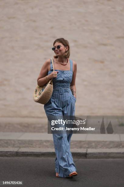 Aline Kaplan wearing Veronica Beard striped blue, green, white cropped top and Veronica Beard matching wide leg pants, Sezane raffia round bag, &...