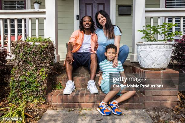portrait of multiracial family on front steps of urban home - die neue normalität stock-fotos und bilder
