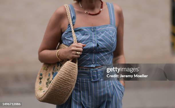 Aline Kaplan wearing Veronica Beard striped blue, green, white cropped top and Veronica Beard matching wide leg pants, Sezane raffia round bag, &...