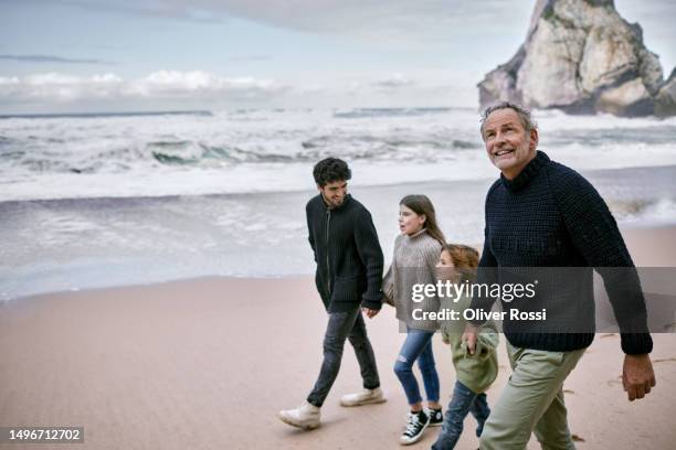 grandfather, father and children walking at the beach - generational family stock pictures, royalty-free photos & images