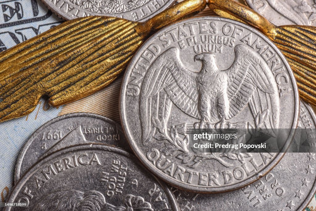 Quarter dollar over 100 dollar bill