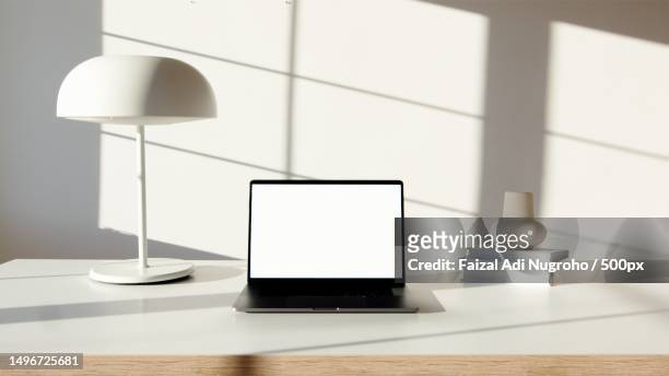 close-up of laptop with digital tablet on table - table only close up stock-fotos und bilder