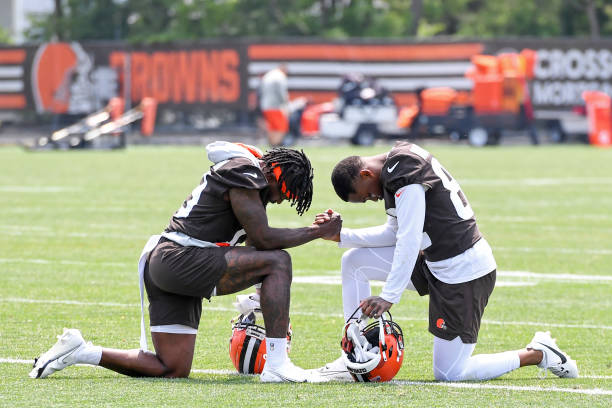 Marquise Goodwin and Mike Harley Jr. #82 of the Cleveland Browns kneel to pray after the Cleveland Browns mandatory veteran minicamp at CrossCountry...