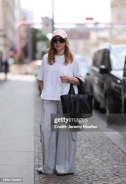 Sonia Lyson wearing The Frankie shop grey wide leg cargo pants, Weekday white cropped oversized shirt, Vee Collective Carba small black puffer bag,...