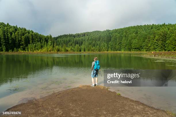 women on the lake shore of seven cities lagoon on azores island, - água parada imagens e fotografias de stock