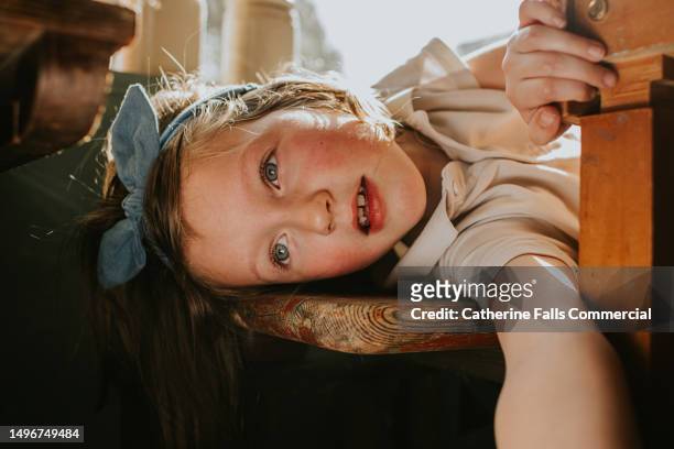 a cute little girl wearing a bowl lies down and smiles - hair bow stock pictures, royalty-free photos & images