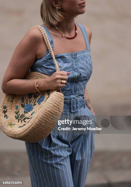 Aline Kaplan wearing Veronica Beard striped blue, green, white cropped top and Veronica Beard matching wide leg pants, Sezane raffia round bag, &...