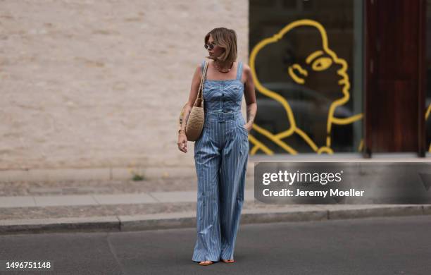 Aline Kaplan wearing Veronica Beard striped blue, green, white cropped top and Veronica Beard matching wide leg pants, Sezane raffia round bag, &...