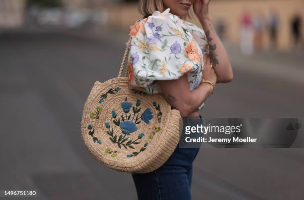 Aline Kaplan wearing Baum & Pferdgarten wide leg blue denim pants, & other stories white flower pattern cropped blouse and orange summer heels and...