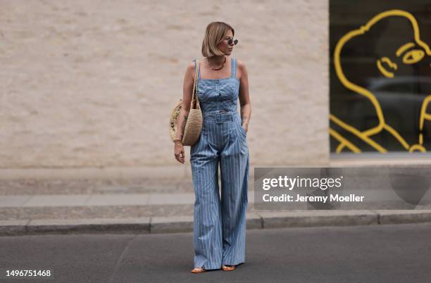 Aline Kaplan wearing Veronica Beard striped blue, green, white cropped top and Veronica Beard matching wide leg pants, Sezane raffia round bag, &...