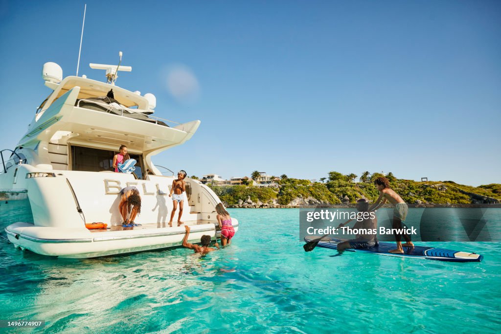 Wide shot of family playing at stern of yacht during vacation