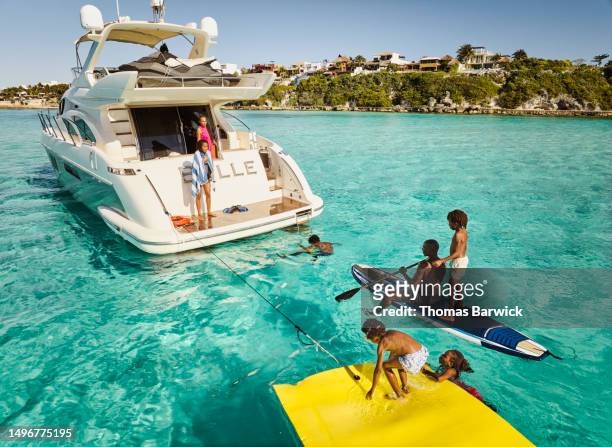 Wide shot of family playing at stern of yacht during vacation