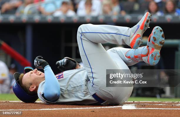 Pete Alonso of the New York Mets falls to the ground after he is hit by pitch in the first inning against Charlie Morton of the Atlanta Braves at...