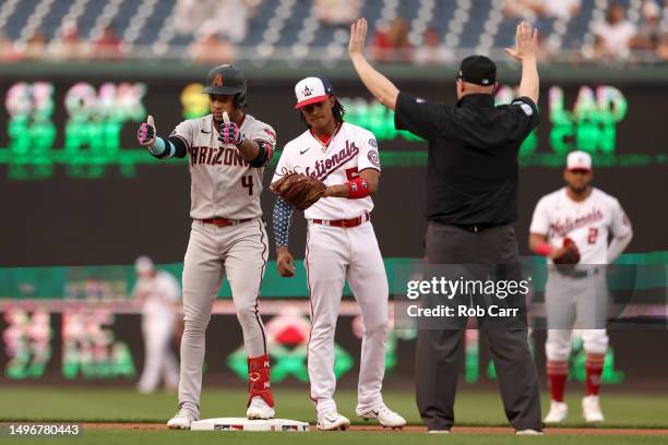 Ketel Marte of the Arizona Diamondbacks celebrates toward the dugout in front of CJ Abrams of the Washington Nationals after doubling in the first...