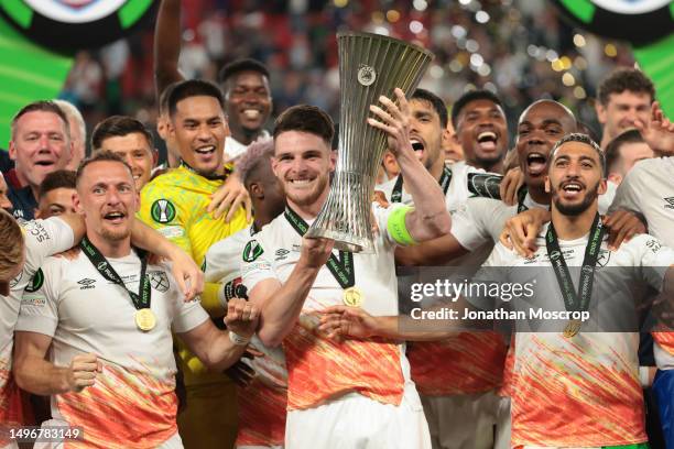 Declan Rice of West Ham United lifts the Winners' trophy as he celebrates with team mates on the podium following the UEFA Europa Conference League...