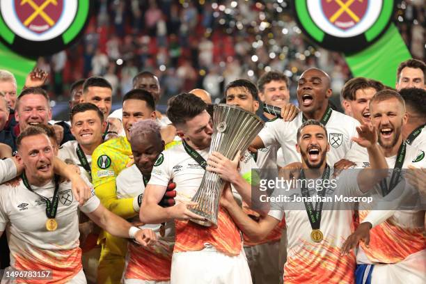 Declan Rice of West Ham United lifts the Winners' trophy as he celebrates with team mates on the podium following the UEFA Europa Conference League...