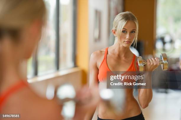 caucasian woman exercising with dumbbells - bodybuilder flexing biceps stock pictures, royalty-free photos & images