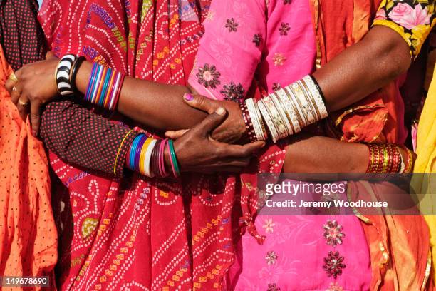 women in traditional indian clothing hugging - rajasthani women stock-fotos und bilder