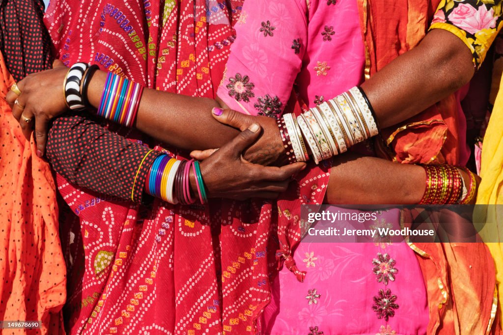 Women in traditional Indian clothing hugging